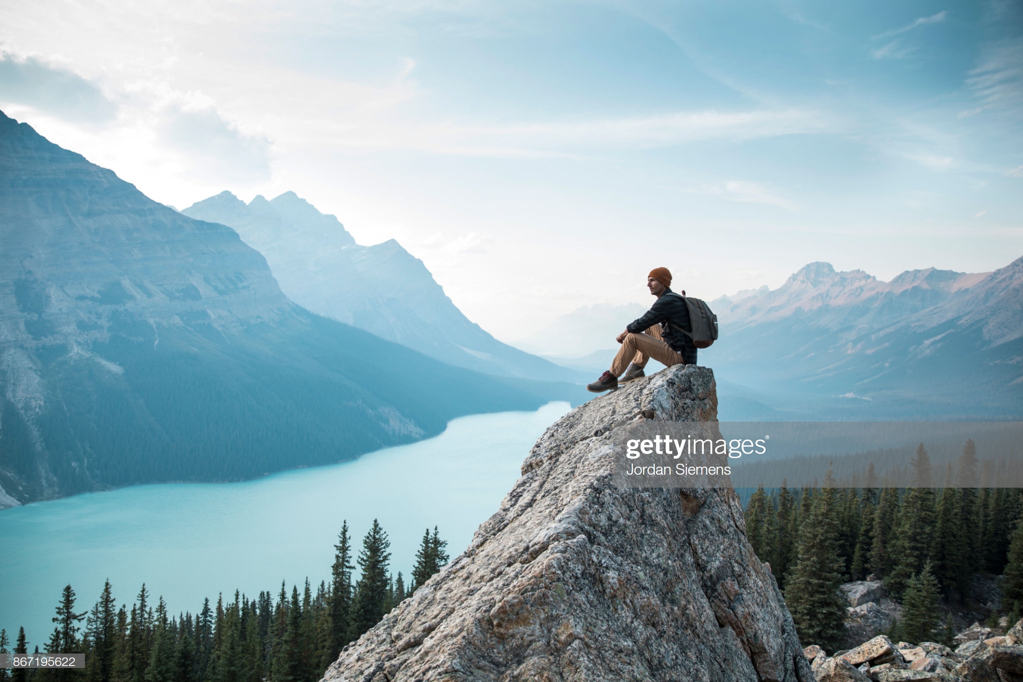 A young man sitting on a rock overlooking Peyto Lake.