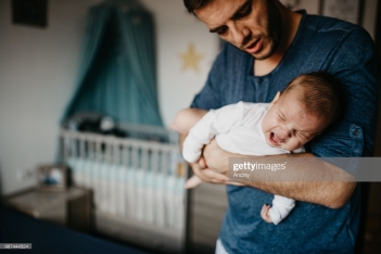 Dad Holding crying baby in the colic carry
