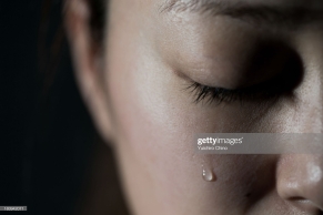 Young woman crying with tear drop.