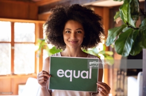 Young african american woman holding sign stands for equal rights.